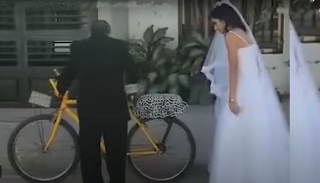Gesto. La novia fue a casarse llevada por su papá en s bicicleta. (Imagen de video)