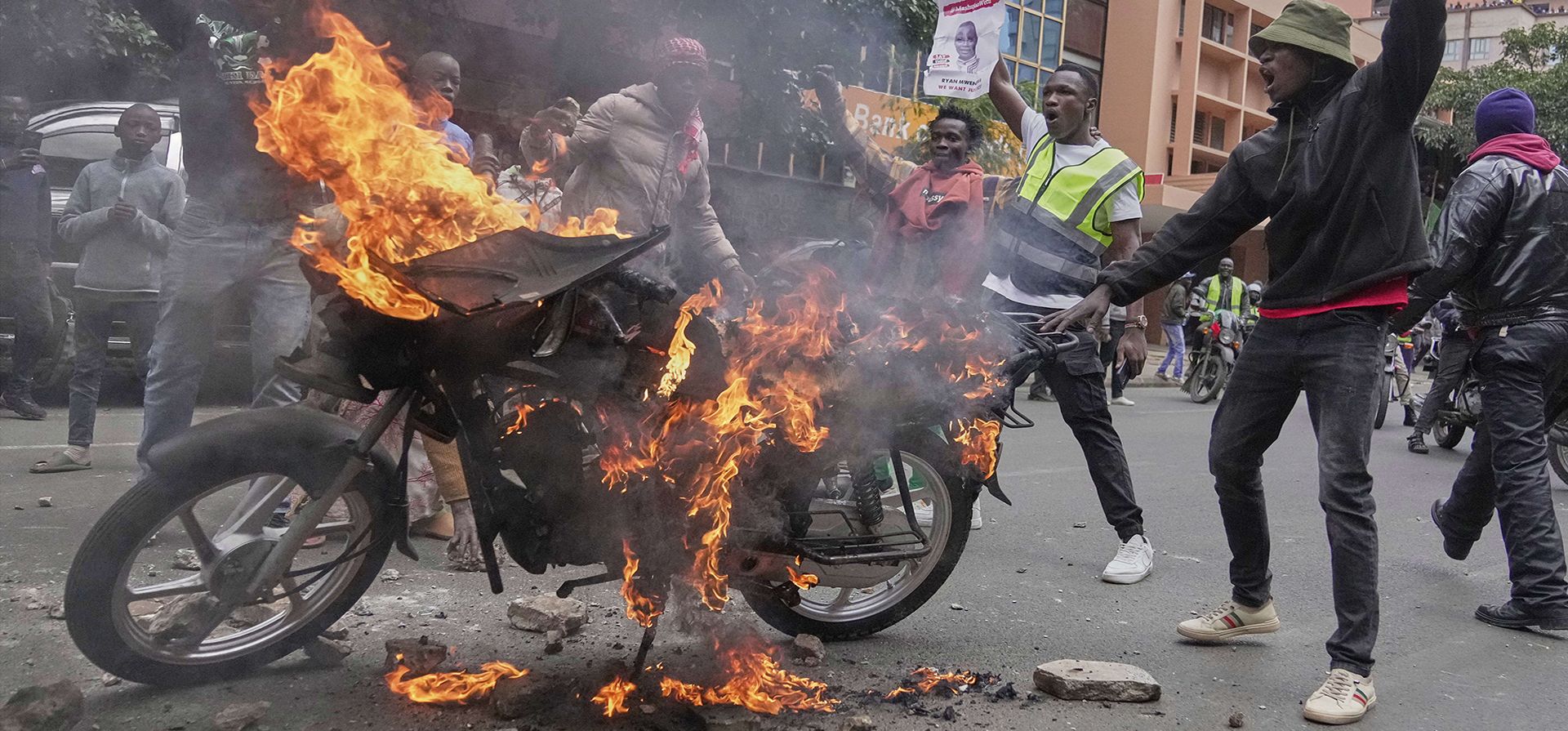 Manifestantes hacen un gesto frente a una motocicleta en llamas durante una protesta por la muerte del bloguero Albert Ojwang bajo custodia policial, en el centro de Nairobi, Kenia, el martes 17 de junio de 2025. (Foto AP/Brian Inganga) Manifestantes hacen un gesto frente a una motocicleta en llamas durante una protesta por la muerte del bloguero Albert Ojwang bajo custodia policial, en el centro de Nairobi, Kenia, el martes 17 de junio de 2025. (Foto AP/Brian Inganga)