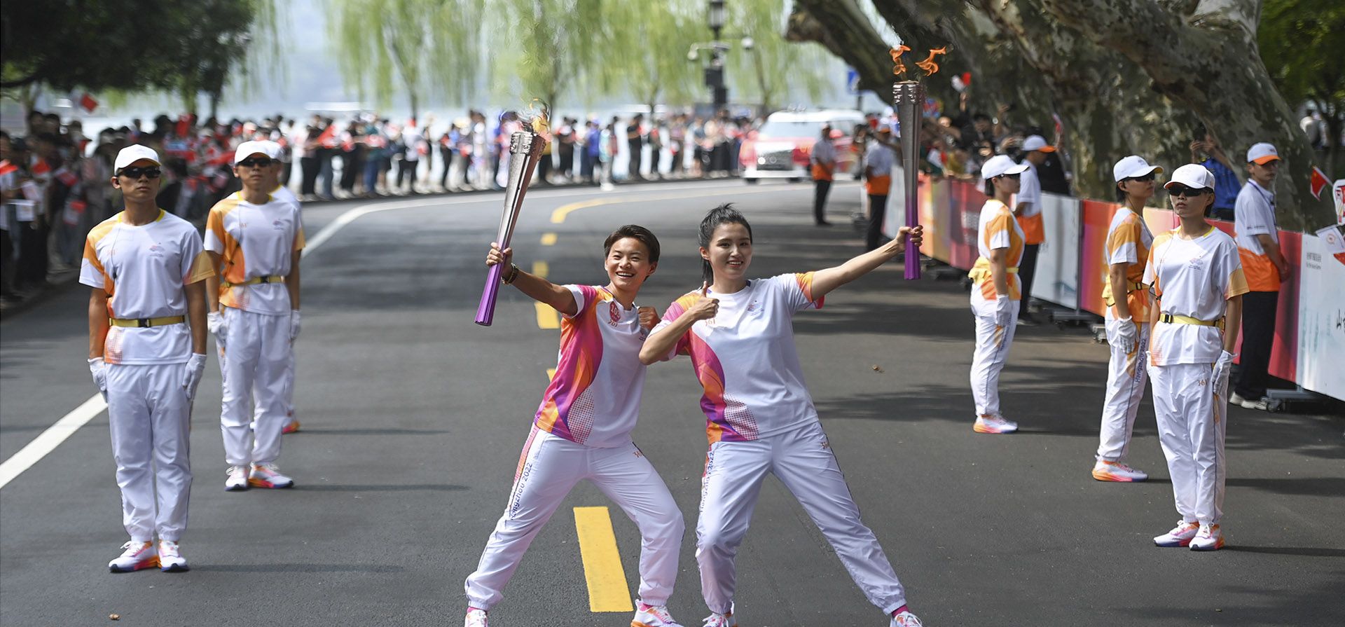 Portadores de la antorcha Wang Shuang y Wang Qinou a la derecha posan para fotografías durante el relevo de la antorcha de los 19º Juegos Asiáticos en Hangzhou, en la provincia de Zhejiang, en el este de China, el viernes 8 de septiembre de 2023. (Huang Zongzhi/Xinhua vía AP Portadores de la antorcha Wang Shuang y Wang Qinou a la derecha posan para fotografías durante el relevo de la antorcha de los 19º Juegos Asiáticos en Hangzhou, en la provincia de Zhejiang, en el este de China, el viernes 8 de septiembre de 2023. (Huang Zongzhi/Xinhua vía AP