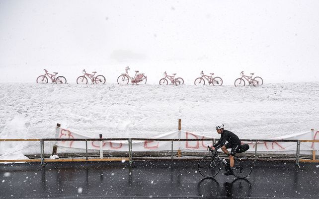 Un ciclista en solitario pedalea bajo la nieve en las montañas Dolomitas Giau Pass