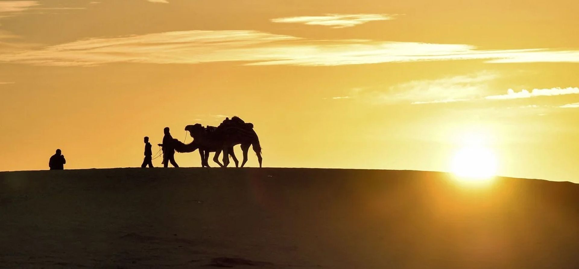 Los camelleros conducen a sus animales a través de las dunas de arena en Ong Jemel (Cuello de camello), cerca del Chott (lago salado) de Chtihatt Sghat, al norte del oasis de Nefta, en el suroeste de Túnez.