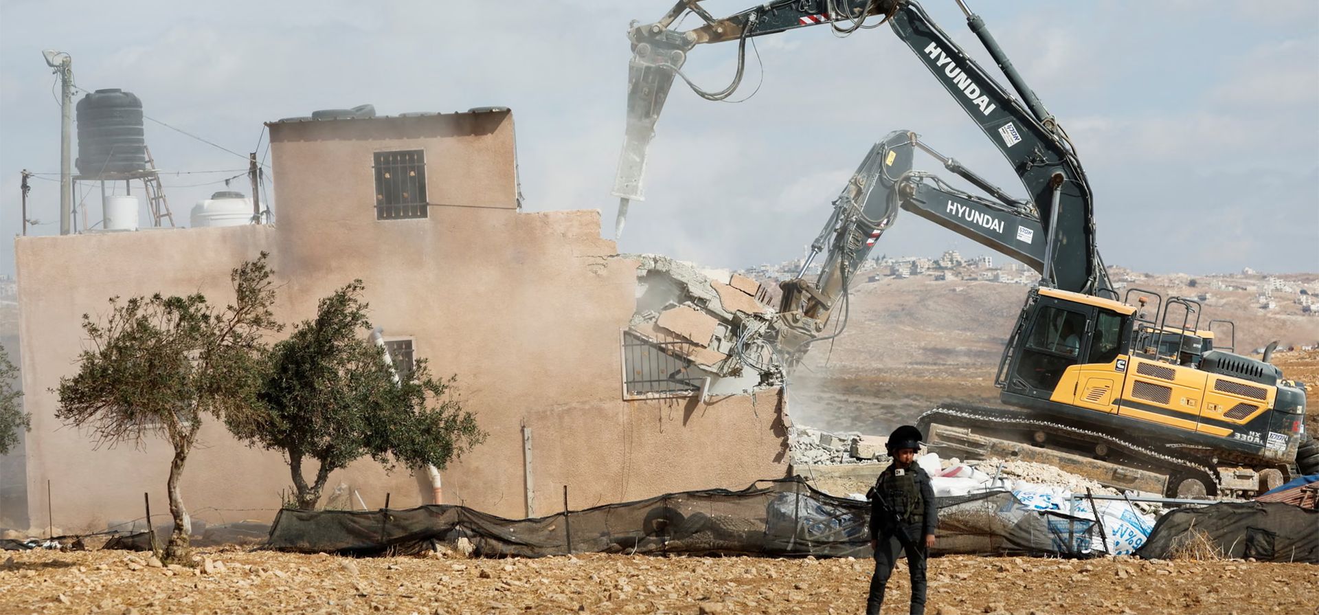 Un miembro de las fuerzas israelíes monta guardia durante la demolición de un edificio palestino en el territorio ocupado por Israel, Hebrón, Cisjordania. Fotografía: Mussa Qawasma/Reuters Un miembro de las fuerzas israelíes monta guardia durante la demolición de un edificio palestino en el territorio ocupado por Israel, Hebrón, Cisjordania. Fotografía: Mussa Qawasma/Reuters