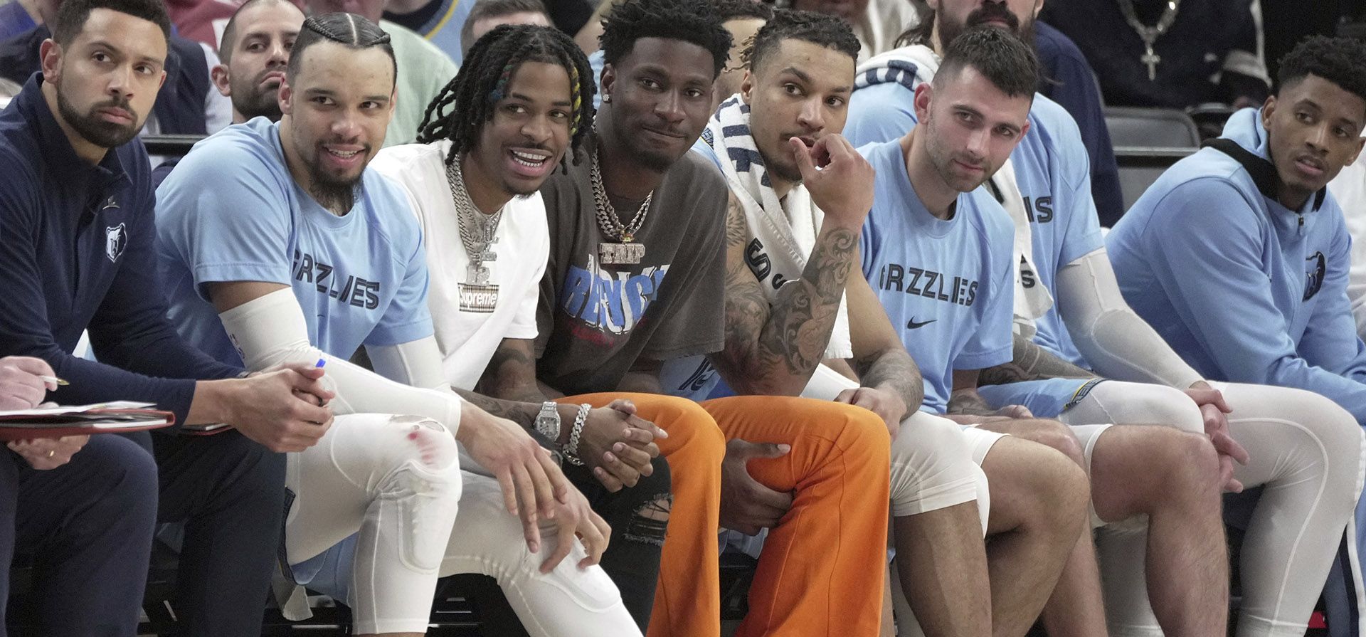 Ja Morant, tercero desde la izquierda, de los Grizzlies de Memphis, y Jaren Jackson Jr., cuarto desde la izquierda, observan a sus compañeros desde la banca en la segunda mitad de un partido de baloncesto de la NBA contra los Golden State Warriors, el lunes 28 de marzo de 2022, en Memphis. Tennessee.