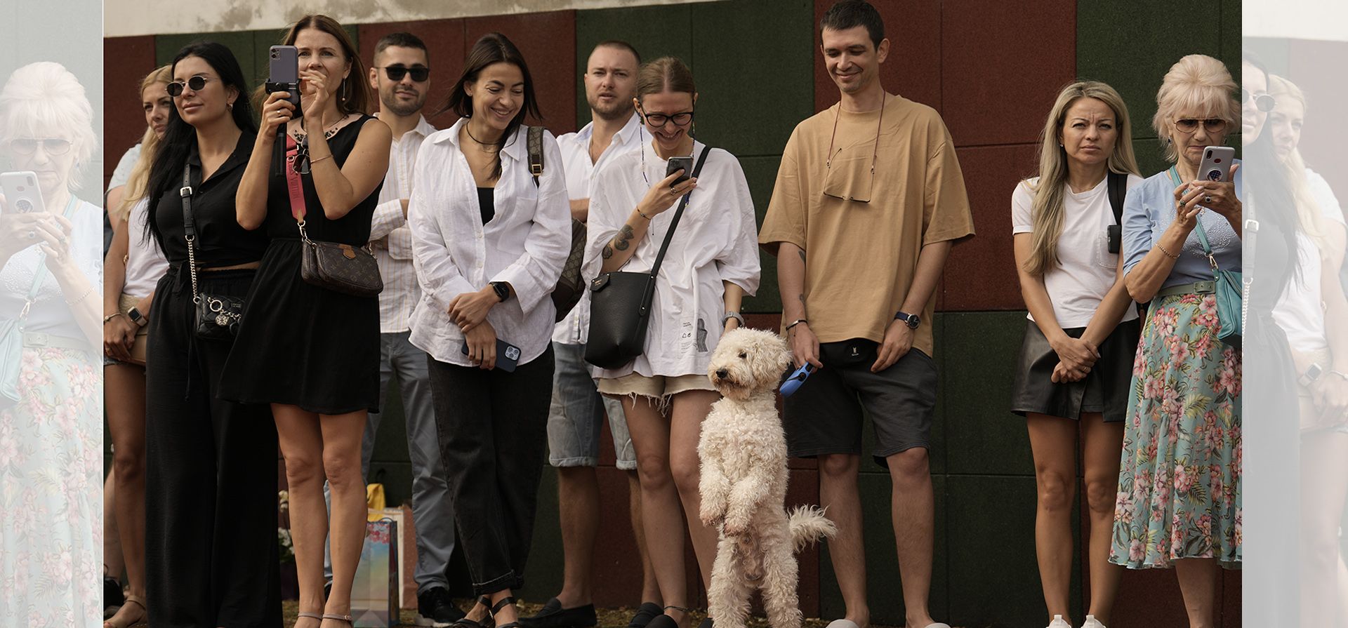 Un perro junto a padres y familiares de niños refugiados ucranianos durante la ceremonia de inauguración de una escuela en Bucarest, Rumania, el jueves 1 de septiembre de 2022. Unos 100 niños comenzaron la escuela el jueves, el mismo día en que abren las escuelas en Ucrania, antes de lo anunciado oficialmente.