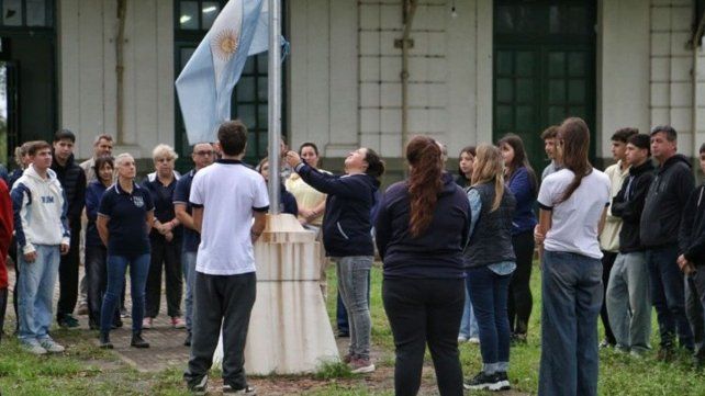 El reducido grupo escolar que regresó este jueves a la Mariano Moreno en el primera izamiento de la bandera después del tiroteo fatal.