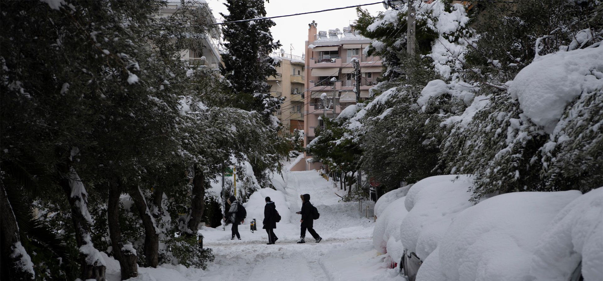 Gente camina en el suburbio de Cholargos en Atenas después de una tormenta de nieve. La caida de nieve de gran intensidad interrumpió el tráfico aéreo y por carretera el lunes en la capital griega de Atenas y en la vecina ciudad más grande de Turquía, Estambul.