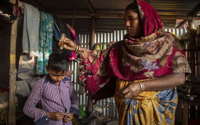 Una madre india ayuda a su hijo para ir a la escuela