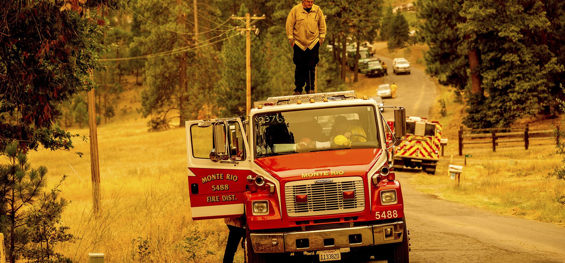 Un bombero se para sobre un camión cisterna poco después de entrar en servicio para combatir el incendio de Oak en la comunidad de Jerseydale del condado de Mariposa, California, el domingo 24 de julio de 2022.