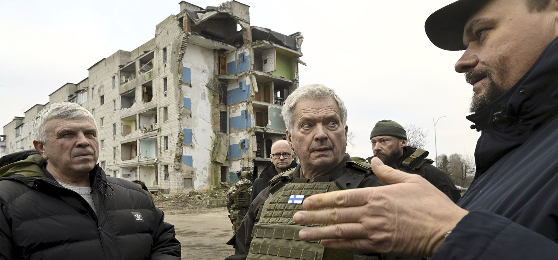 El presidente finlandés, Sauli Niinistö, con funcionarios locales y tropas caminando por el área destruida en Borodyanka, Ucrania, el martes 24 de enero de 2023. (Markku Ulander/Lehtikuva vía AP)