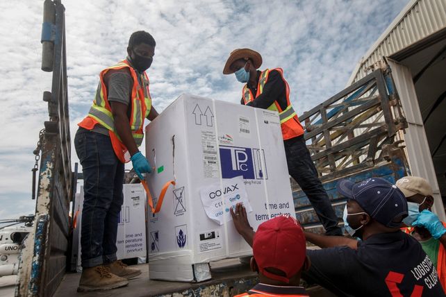 EMBARQUE. Cajas con dosis de AstraZeneca son descendidas en el aeropuerto de la nación africana de Somalia.