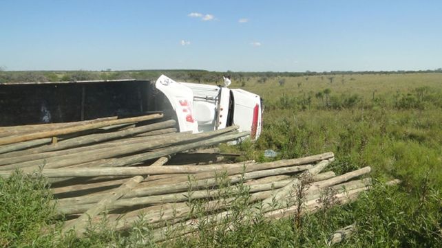 Un camión con postes de madera chocó y volcó su carga