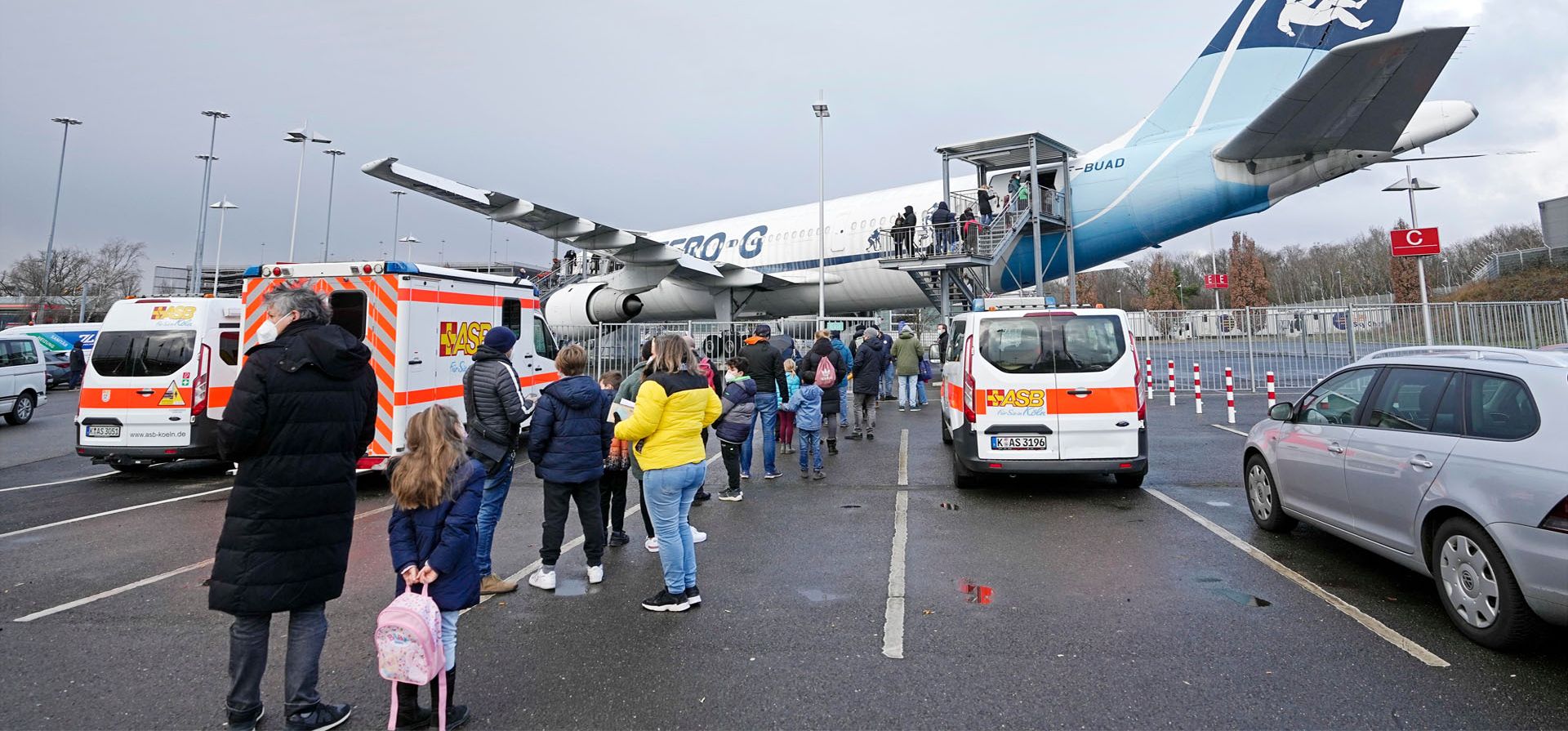 Familias hacen fila frente a un avión Airbus A300 Zero G, donde niños de entre 5 y 11 años reciben una vacuna contra el coronavirus en el aeropuerto de Colonia, Alemania. El centro de vacunación en el interior de aviones es para promover las vacunas COVID-19 como un evento emocionante para los niños.