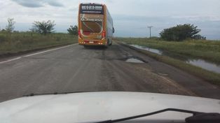 Un ómnibus de larga distancia esquiva un pozo sobre la ruta nacional 11.