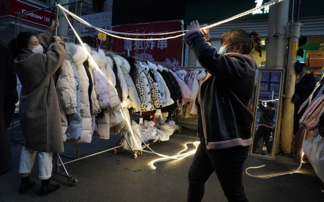 Vendedores ambulantes preparan su negocio en un mercado nocturno en Wuhan, China.
