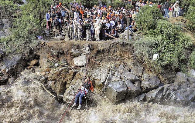 Rescate.  Peregrinos esperan para pasar un río en el norte de la India.