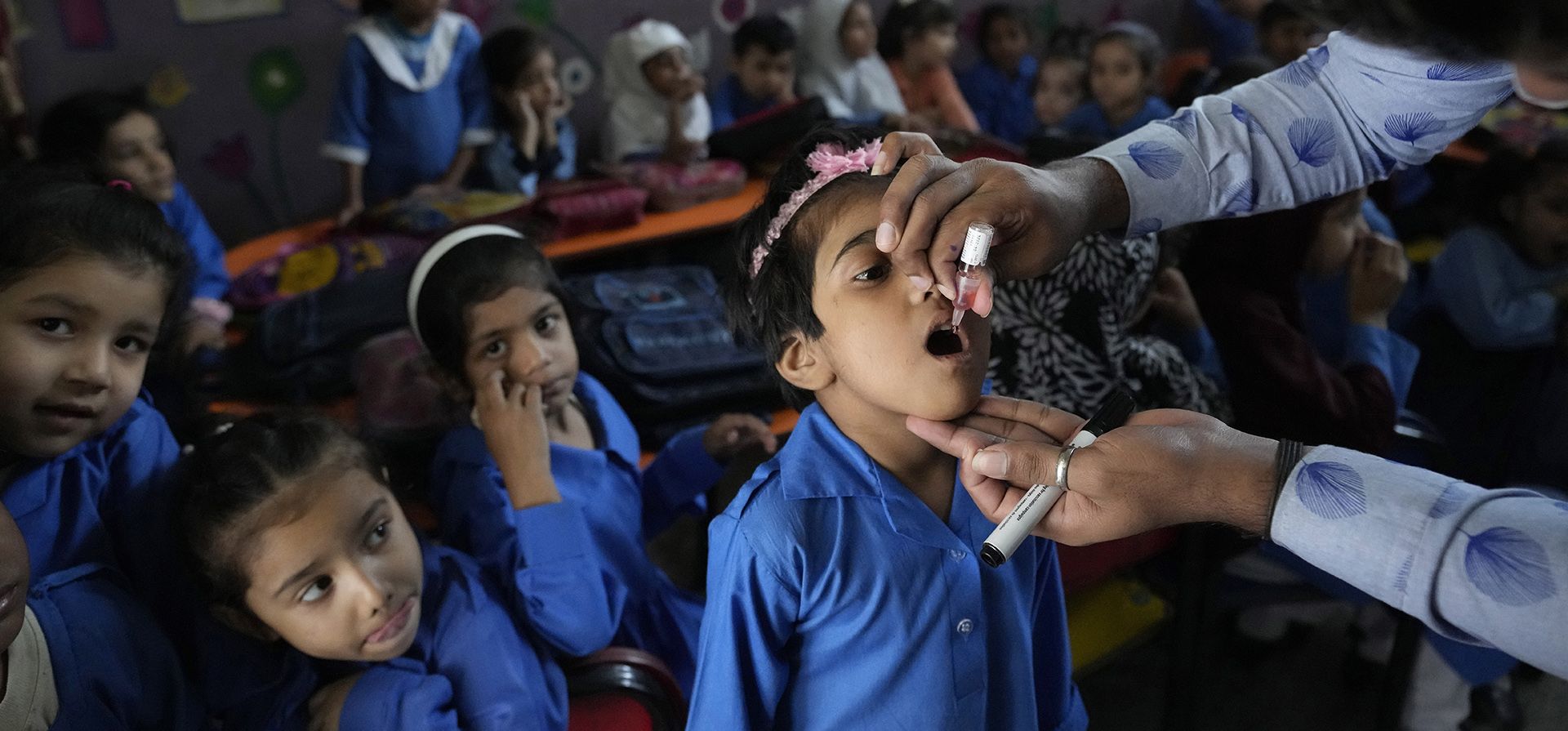 Un trabajador de la salud administra una vacuna contra la poliomielitis a un niño en una escuela en Lahore, Pakistán, el lunes 24 de octubre de 2022.