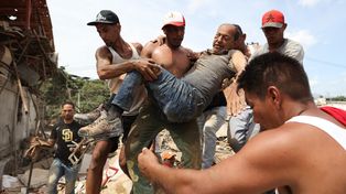 Un grupo de vecinos saca a un hombre de entre los escombros en La Guaira, Venezuela.