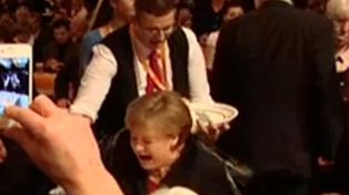 La canciller Merkel fue ba&ntilde;ada de cerveza