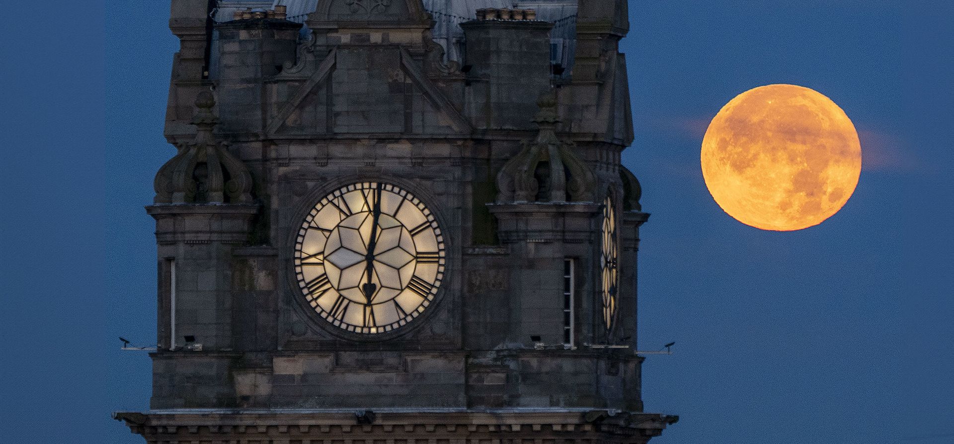 La súper luna azul se pone detrás del Reloj Balmoral en Edimburgo el jueves 31 de agosto de 2023. (Jane Barlow/PA vía AP )