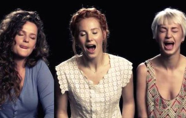 Las mujeres aparecen en primer plano sobre un fondo negro cantando mientras se masturban con un vibrador.