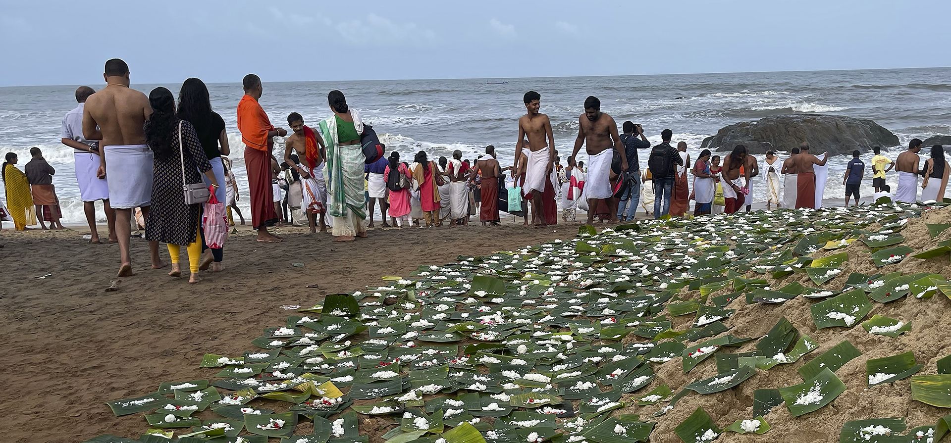 El arroz cocido se mantiene en hojas de plátano como ofrenda a los antepasados en la costa del Mar Arábigo mientras los devotos hindúes realizan rituales durante el festival El arroz cocido se mantiene en hojas de plátano como ofrenda a los antepasados en la costa del Mar Arábigo mientras los devotos hindúes realizan rituales durante el festival