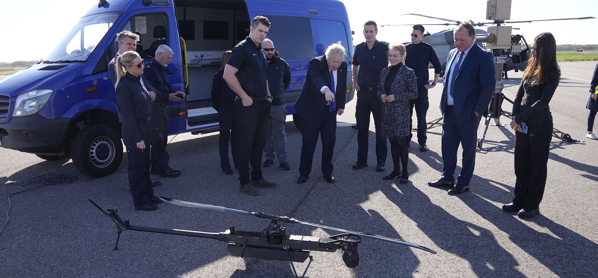 El primer ministro británico, Boris Johnson, mira un dron para la vigilancia y el rescate de migrantes, mientras se reúne con tripulaciones y personal técnico, en el aeropuerto de Lydd, en el sureste de Inglaterra, el jueves 14 de abril de 2022.