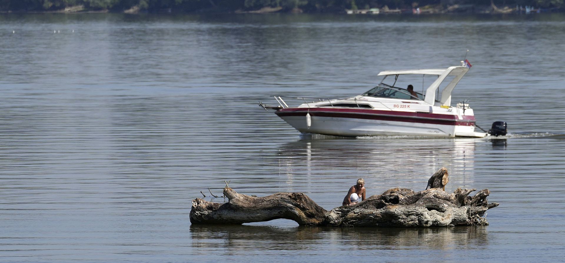 Una mujer y un niño se refrescan en el banco de arena del río Danubio en Belgrado, Serbia, el viernes 22 de julio de 2022. El calor se hizo presente con temperaturas que suben hasta los 39 grados centígrados en Serbia.
