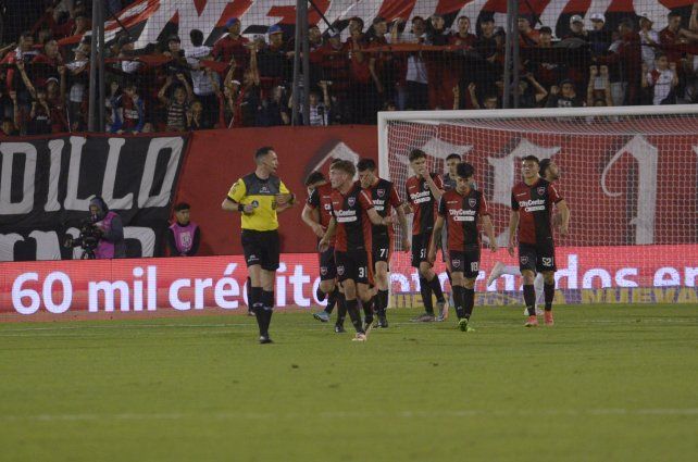 Todo Newells le protesta al árbitro Pablo Dóvalo.