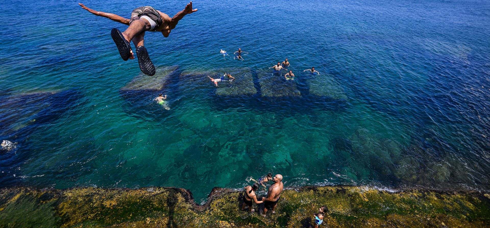 Un joven salta al agua para refrescarse en un día de calor sofocante en el mar Mediterráneo en Beirut, Líbano. Se pronostica que la temperatura alcanzará los 40 grados Celsius, en algunas partes del país. (Foto AP/Hassan Ammar)