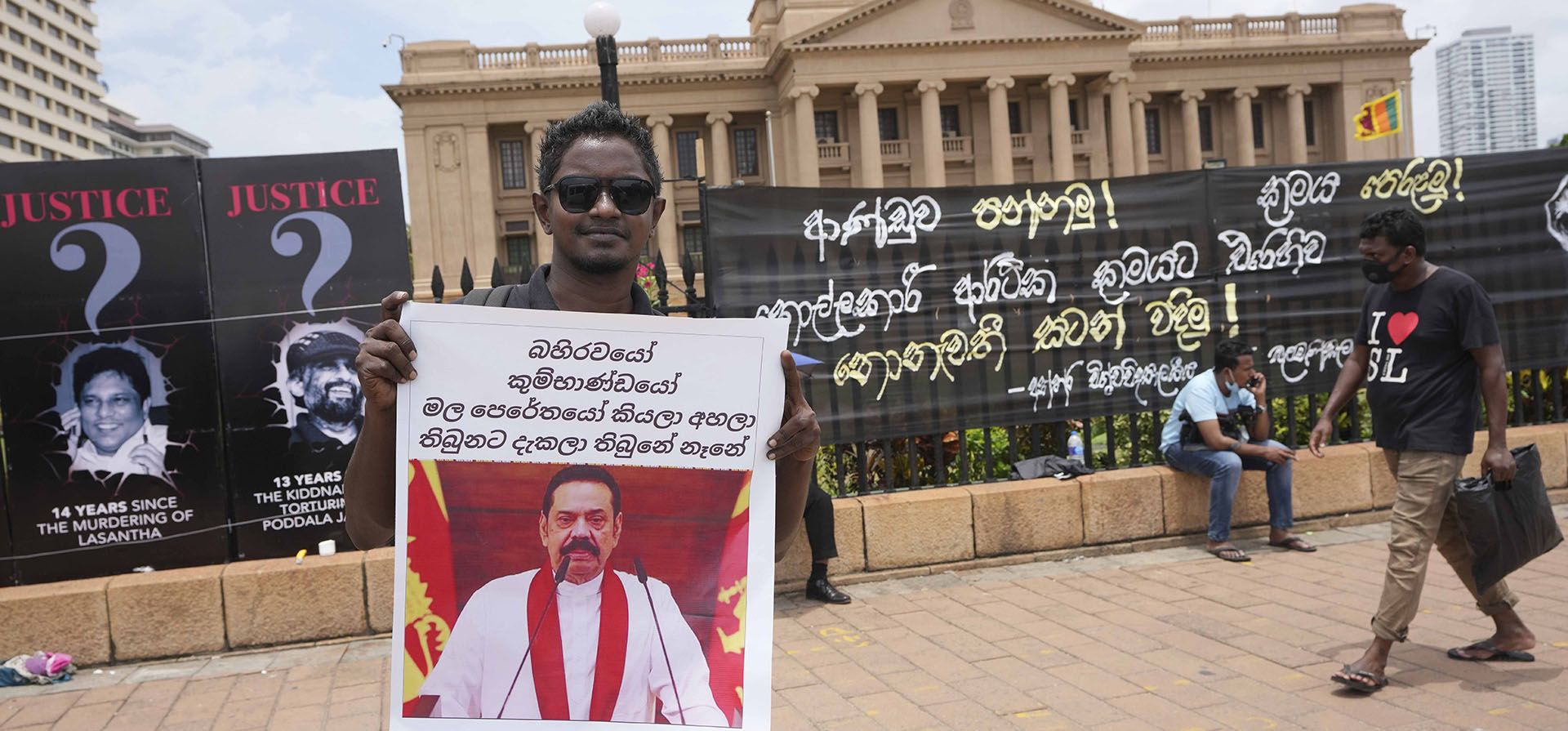 Un manifestante sostiene una pancarta con el retrato del primer ministro Mahinda Rajapaksa cerca de la oficina del presidente en Colombo, Sri Lanka, el miércoles 13 de abril de 2022. El primer ministro de Sri Lanka se ofreció el miércoles a reunirse con los manifestantes que ocupan la entrada de la oficina del presidente, diciendo escucharía sus ideas para resolver los desafíos económicos, sociales y políticos que enfrenta el país.