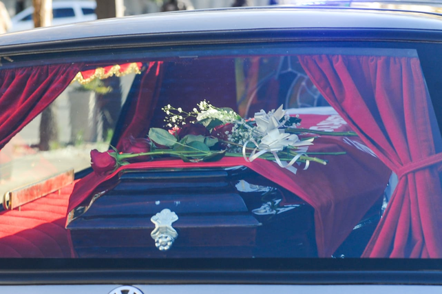 Rosas rojas y las banderas argentina y del socialismo sobre el f&eacute;retro.&nbsp;