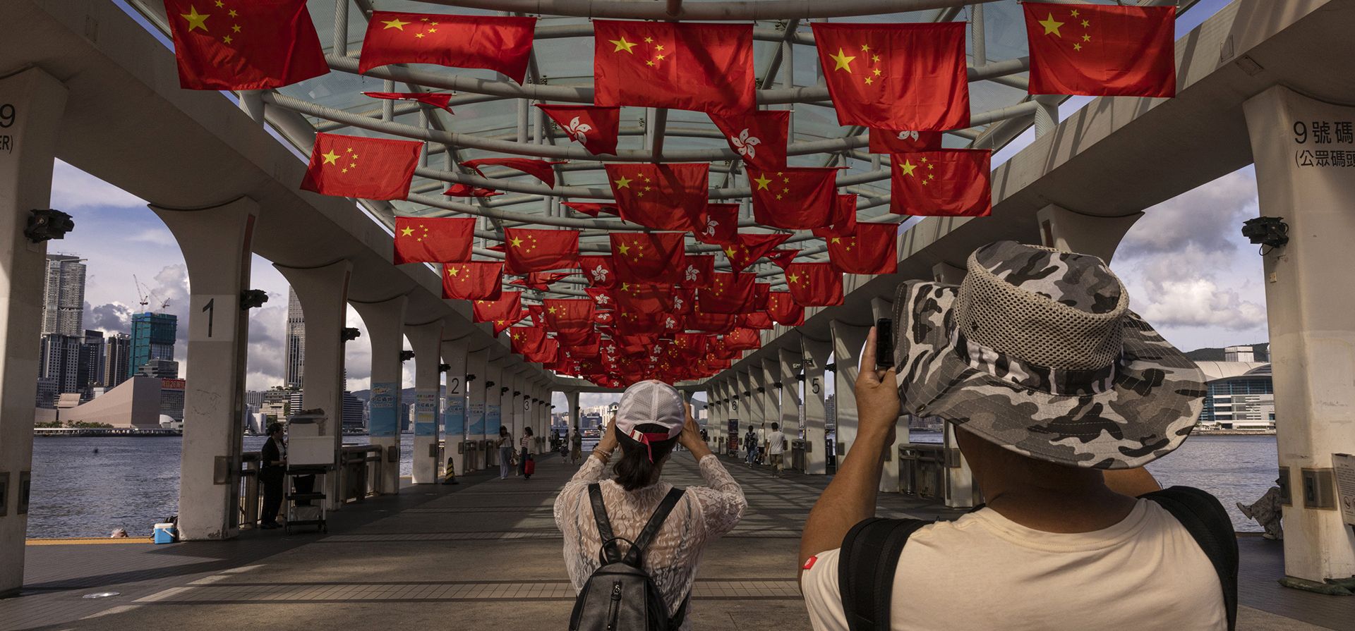 Turistas de China continental toman fotografías mientras se cuelgan banderas de China y Hong Kong para conmemorar el 26° aniversario del traspaso de la ciudad de Gran Bretaña a China en Hong Kong, el martes 27 de junio de 2023. (Foto AP/Louise Delmotte) Turistas de China continental toman fotografías mientras se cuelgan banderas de China y Hong Kong para conmemorar el 26° aniversario del traspaso de la ciudad de Gran Bretaña a China en Hong Kong, el martes 27 de junio de 2023. (Foto AP/Louise Delmotte)